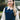 Blonde woman wearing navy blue cable knit sweater vest layered over white collared shirt