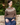 Model wearing hazel brown Fair Isle merino lambswool cardigan sitting on a wooden bench outdoors