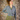 Model wearing 1950s style gray cardigan buttoned over a green floral dress