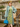 Three-quarter view of woman wearing retro sage floral shirt dress paired with pastel coat and beret