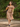 Woman walking down a path in retro midcentury ditsy floral print midi dress carrying a jacket
