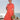 Woman in 1940s salmon pink shirtwaist dress with teal piping posing by the sea
