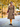 Model wearing hickory brown flecked Sunday Best swing coat styled with mustard tights and a red handbag outdoors