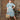 Redhead woman posing in white 1950s shirtwaist dress with blue rose print and vintage bag