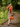 Model wearing sunset orange cardigan over floral dress in garden setting
