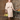 Redhead woman in studio posing in 1940s champagne dress and bolero set with green bag
